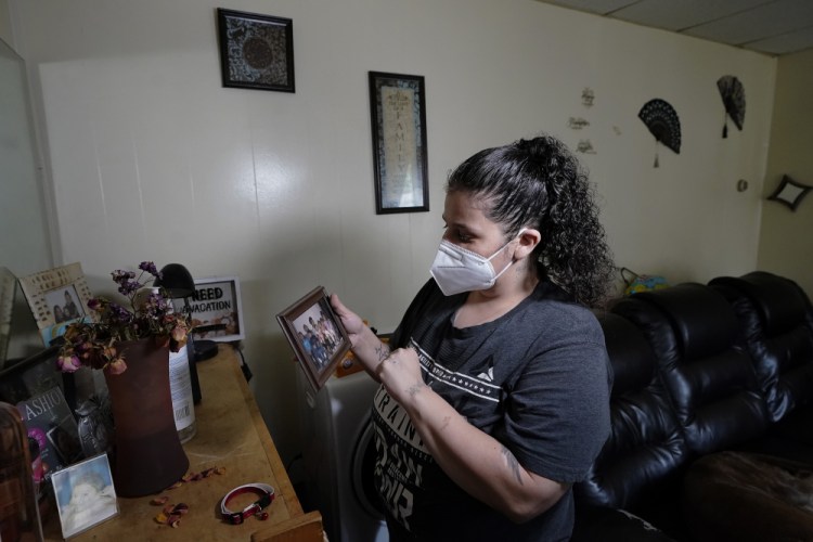 Roxanne Schaefer holds a photograph in the living room of her apartment, in West Warwick, R.I., on Tuesday. 


