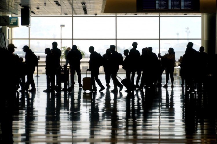 Travelers walk through Salt Lake City International Airport. 