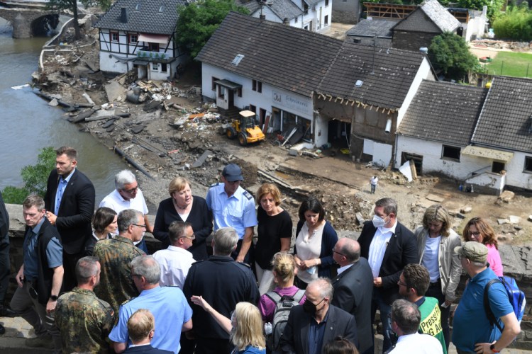 German Chancellor Angela Merkel, rear third left, and the Governor of the German state of Rhineland-Palatinate, Malu Dreyer, rear fifth left, are seen on a bridge in Schuld, western Germany, on Sunday during their visit in the flood-ravaged areas to survey the damage and meet survivors. 