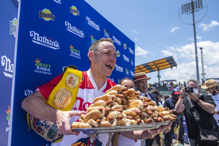 Winners Joey Chestnut and Michelle Lesco, obscured behind hot dogs, pose at the Nathan's Famous Fourth of July International Hot Dog-Eating Contest in Coney Island's Maimonides Park on Sunday in the Brooklyn borough of New York.
