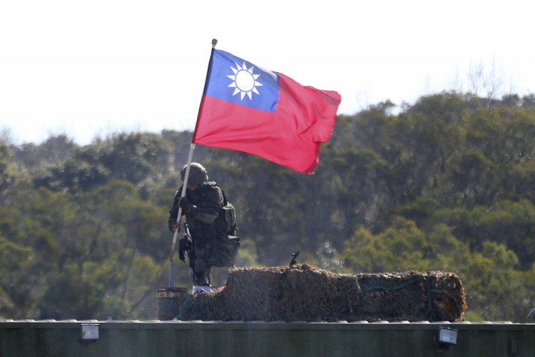 A soldier holds a Taiwanese flag during a military exercise aimed at repelling an attack from China in Hsinchu County, northern Taiwan in January. 