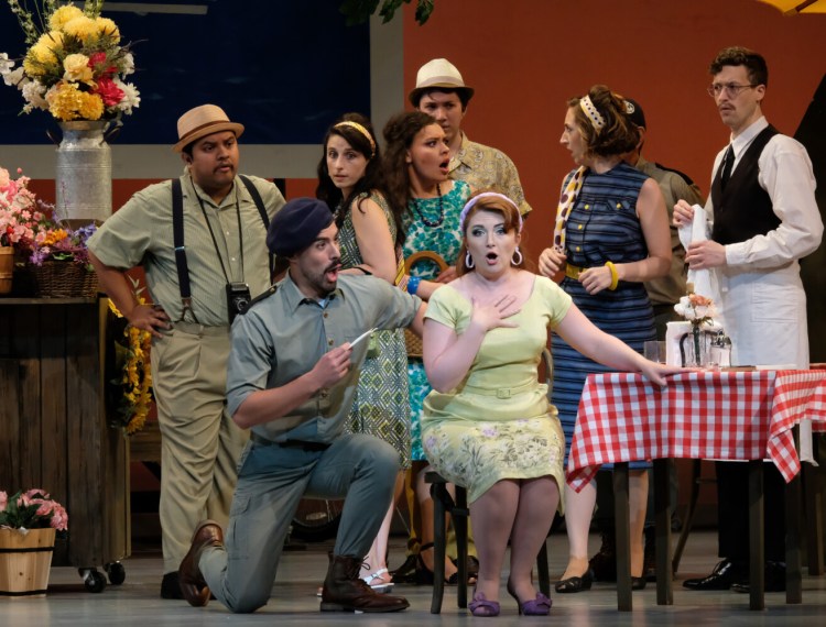 Luis Orozco as Belcore, kneeling, and Sarah Tucker as Adina, sitting, with the ensemble of "The Elixir of Love."