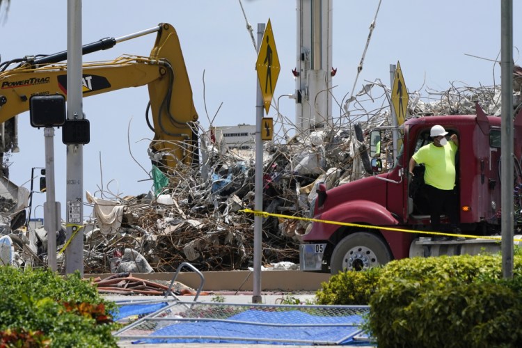 A worker waits to load his truck with debris from the rubble of the Champlain Towers South building, as removal and recovery work continues at the site of the partially collapsed condo building, Wednesday, July 14, in Surfside, Fla. 