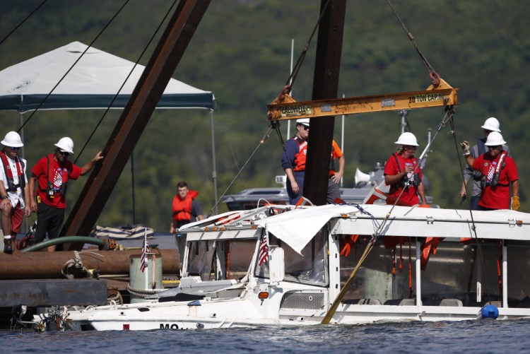 A duck boat that sank in Table Rock Lake in Branson, Mo., is raised after it went down the evening of July 19, 2018, when a thunderstorm generated near-hurricane strength winds, killing 17 people. A county prosecutor and Missouri Attorney General Eric Schmitt filed state charges on Friday against three employees of the tourist attraction in connection with the boat sinking. 