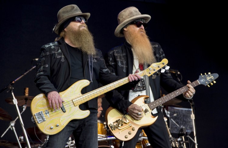Dusty Hill, left, and Billy Gibbons from the rock band ZZ Top perform at the Glastonbury music festival in Somerset, England, in 2016. ZZ Top has announced that Hill, one of the Texas blues trio's bearded figures and bassist, has died at his Houston home. He was 72. 