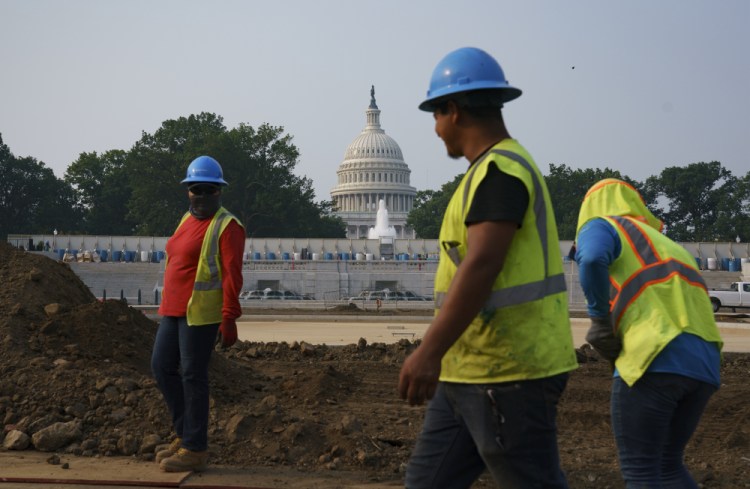 Workers repair a park near the Capitol in Washington on Wednesday.