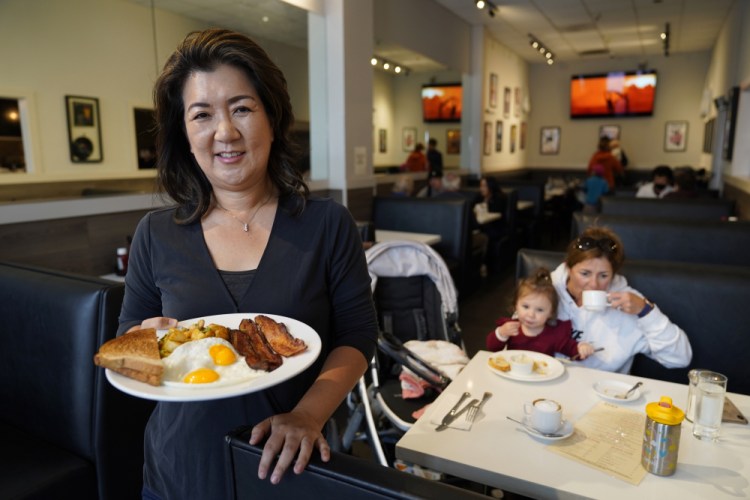 Jeannie Kim holds her popular bacon and eggs breakfast at her restaurant in San Francisco on Friday. 

