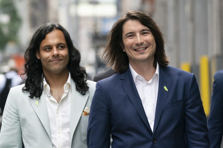 Vladimir Tenev, CEO and co-founder of Robinhood, right, walks in New York's Times Square with fellow co-founder Baiju Bhatt following their company's initial public offering on Wall Street on Thursday. 