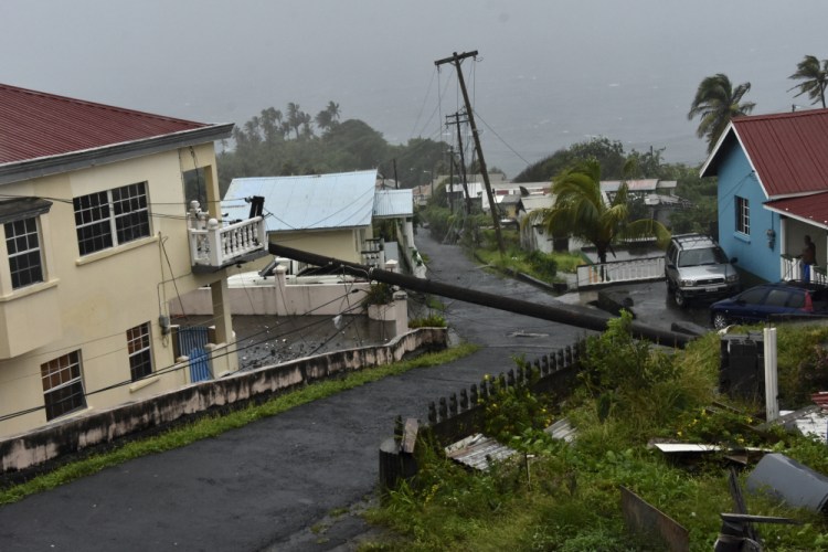 An electrical pole felled by Hurricane Elsa leans on the edge of a residential balcony, in Cedars, St. Vincent, on Friday

