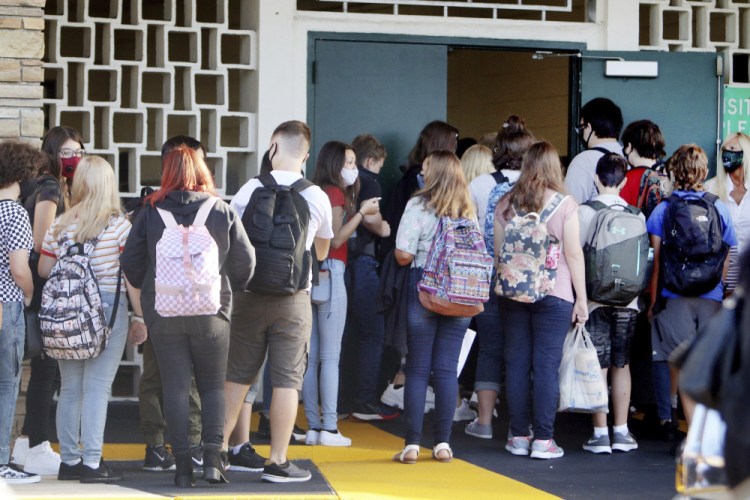Students enter Gulf Middle School during the first day of school for Pasco County Schools in New Port Richey, Fla., in August 2020. The U.S. has seen a string of COVID-19 outbreaks tied to summer camps in recent weeks in Texas, Illinois, Florida, Missouri and Kansas, offering what some fear could be a preview of the upcoming school year in those places. 