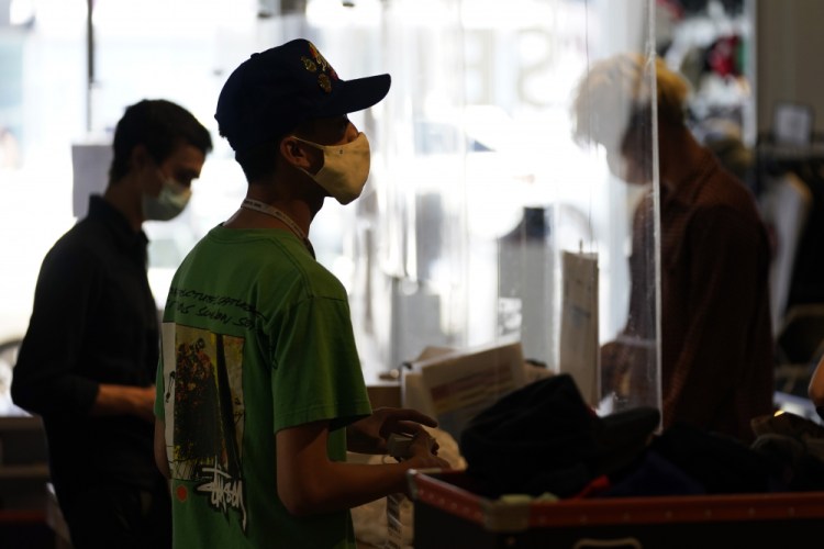 Employees check out customers at 2nd Street second hand store in the Fairfax district of Los Angeles on July 19.  New evidence showing the delta variant is as contagious as chickenpox has prompted U.S. health officials to consider changing advice on how the nation fights the coronavirus. 