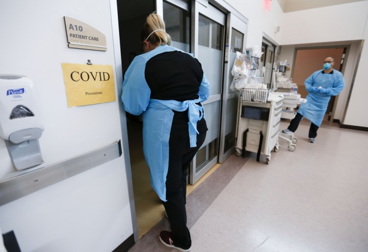 Nurses and doctors in the CoxHealth Emergency Department in Springfield, Mo., don personal protective equipment to treat patients with COVID-19 this month. 