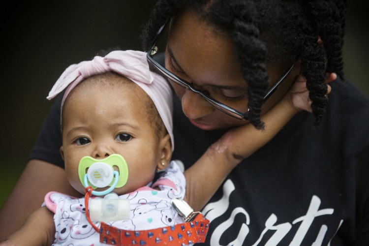 Tyesha Young, who lost her hospital job during the pandemic, holds her baby Jalayah Johnson outside their home in Waggaman, La., on Friday. More than $7,000 behind on rent, Young had hoped a program in Louisiana would bail her out and allow her family to avert eviction in the coming weeks. But the 29-year-old mother of two from Jefferson Parish is still waiting to hear whether any of the $308 million available from the state for rental assistance and utility payments will give her a lifeline. She applied for money last year but never heard anything. 