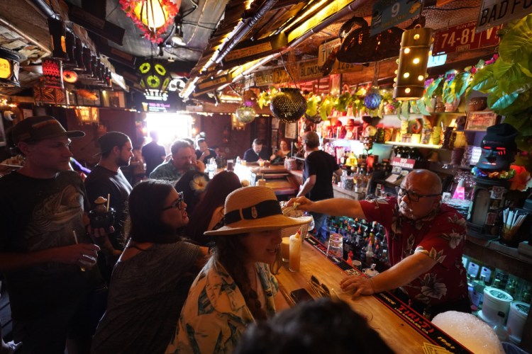 Patrons enjoy tropical cocktails in the tiny interior of the Tiki-Ti bar as it reopens on Sunset Boulevard in Los Angeles this month. COVID-19 cases have doubled over the past three weeks, driven by the fast-spreading delta variant, lagging vaccination rates in some states and Fourth of July gatherings. 