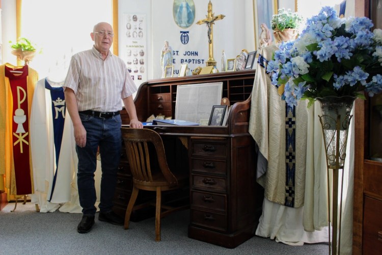 Church Historian Robert Bouchard standing next to the pastor's desk that he believes is one of the oldest artifacts in the museum.