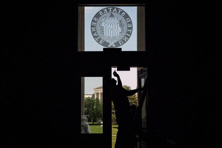 A worker fixes a door at the Capitol in May. MUST CREDIT: Washington Post photo by Jabin Botsford