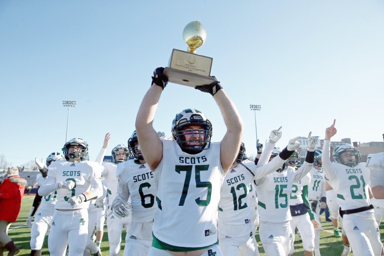 PORTLAND, ME - NOVEMBER 23: Bonny Eagle's Will Horton is surrounded by teammates as he holds the trophy ball up for the crowd in the stands after winning the Class A football state championship game against Thornton Academy on Saturday at Fitzpatrick Stadium. (Staff photo by Ben McCanna/Staff Photographer)