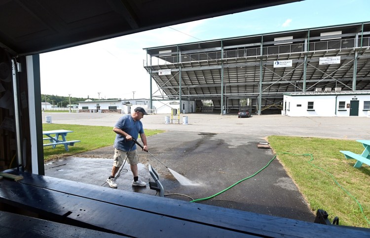Mike Pelletier of M & M Ice Cream power-washes the driveway in front of his ice cream stand near the grandstands Tuesday at the Skowhegan State Fairgrounds. Pelletier, who has served ice cream at the fair since 2012, said he was also power-washing and painting his building before the fair opens. The fair runs from Aug. 12-21.