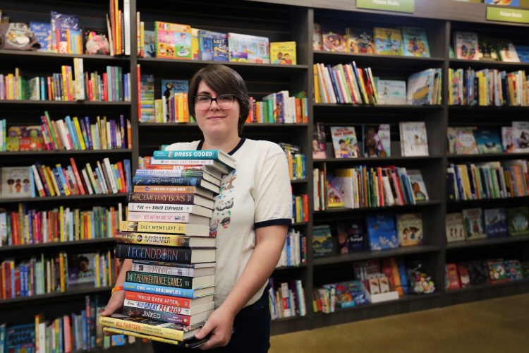 Stephanie Heinz, children's book manager and community coordinator at Print: A Bookstore, holds books that have been donated to replace those that were lost in the fire last week at the Dr. Levesque Elementary School in Frenchville. Heinz said the store started a drive to help replace approximately 9,500 books lost in the fire. So far, about 100 books and $200 in cash have been collected.