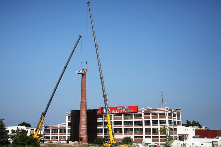 PORTLAND, ME - AUGUST 6:  Workers dangling from a crane use machinery to remove B&M's iconic smokestack brick by brick. (Staff photo by Ben McCanna/Staff Photographer)