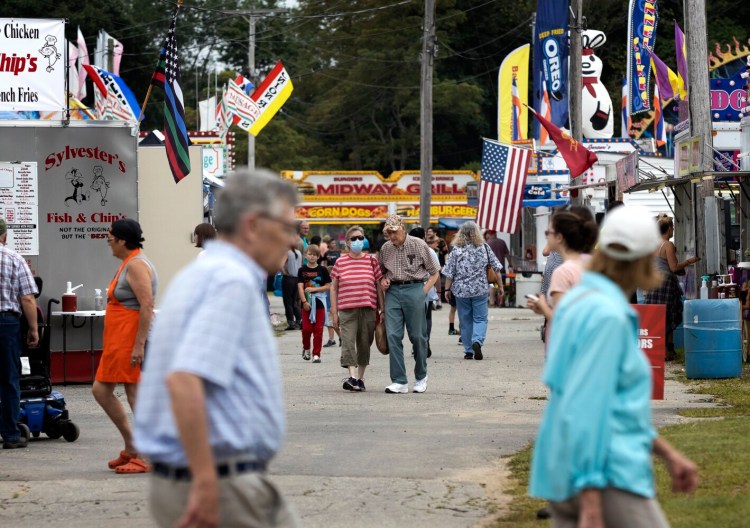 Visitors make their way through the Topsham Fairgrounds on Tuesday. Organizers expect higher-than-usual attendance at the six-day fair, which has attracted 25,000 to 30,000 people in recent years.
