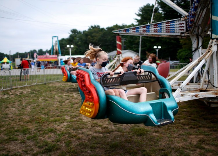 Isabel Chabot, 11, left, and Lyra Ricciardone, 11, both of Bath, spin around on a ride at the Topsham Fair on Tuesday.