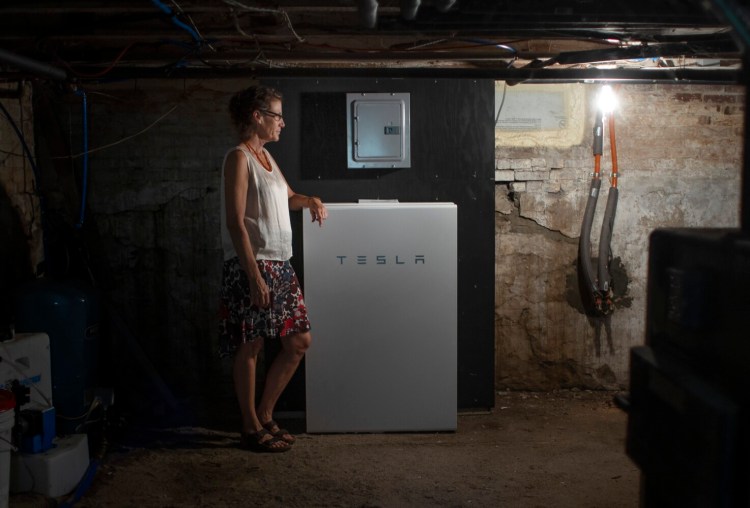 BRUNSWICK, ME - AUGUST 13: Julie Isbill stands next to the Tesla Powerwall battery back-up system in the basement of her home in Brunswick. (Staff photo by Derek Davis/Staff Photographer)