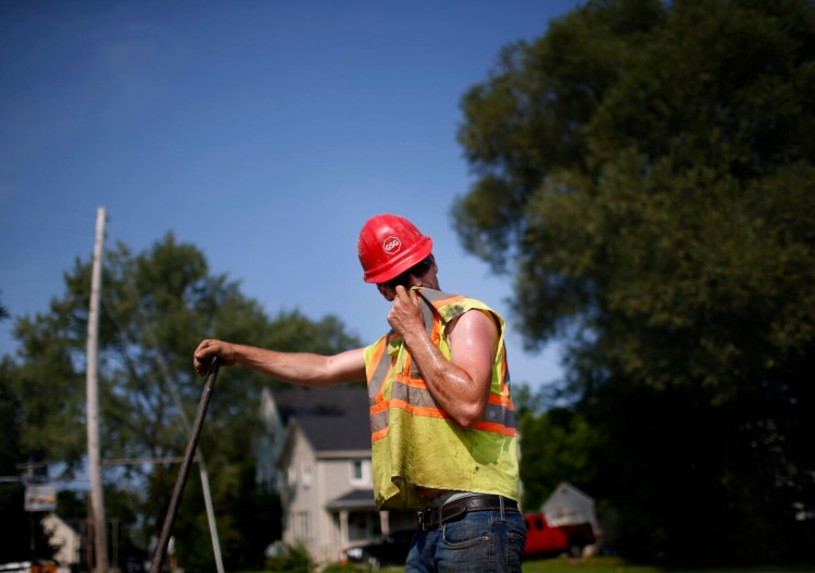 PORTLAND, ME - AUGUST 12: Cody Kinney of Gorham Sand and Gravel wipes sweat from his face while working on Ocean Avenue in Portland on Thursday, Aug. 12, 2021. (Staff photo by Derek Davis/Staff Photographer)