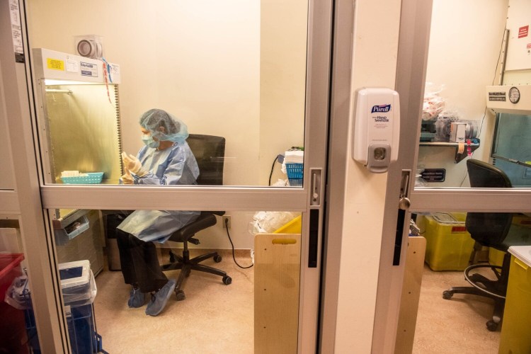 Angela St. Amant, a chemotherapy technician, demonstrates how to prepare a pharmaceutical preparation on Friday, August 13 in a non-hazardous safety cabinet in a sterile clean room at Central Maine Medical Center in Lewiston. This is the same process used to prepare vaccination shots.