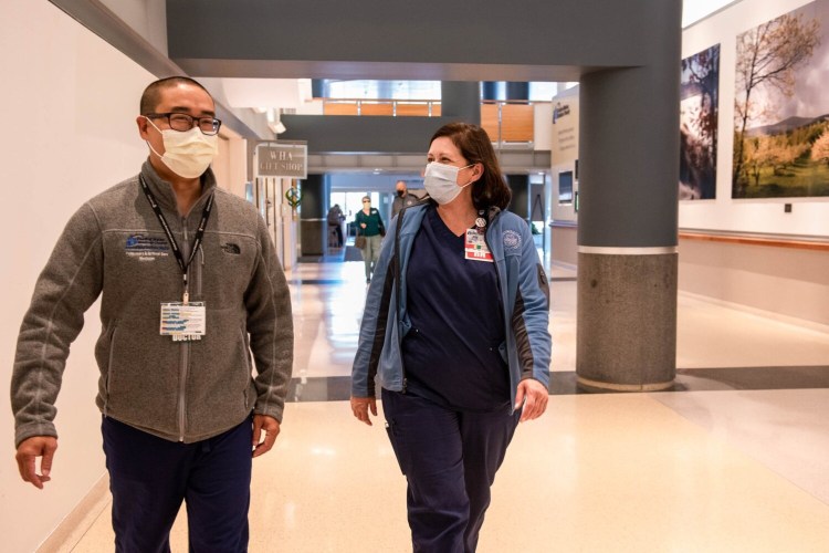 Dr. Al Teng, Chief of Critical Care, and Jennifer Jordan, the
System Director of Medical Specialties walk together on Friday in the hallway of Central Maine Medical Center in Lewiston. Jordan oversees the hospital's mass vaccination program at the Auburn Mall.