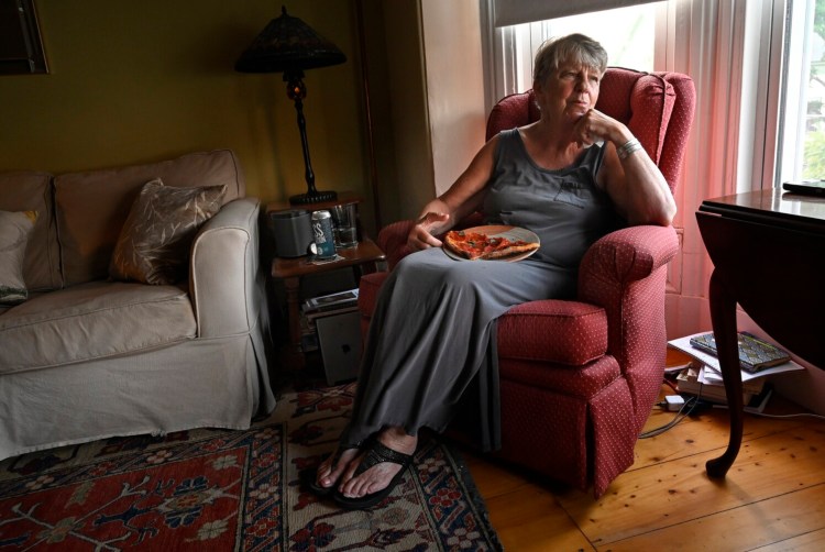 PORTLAND, ME - AUGUST 25: After having a few bites at the kitchen counter Diane moved to the living room to enjoy her pizza Wednesday, August 25, 2021. Diane said she use to hate pizza but now she likes it. (Staff Photo by Shawn Patrick Ouellette/Staff Photographer)