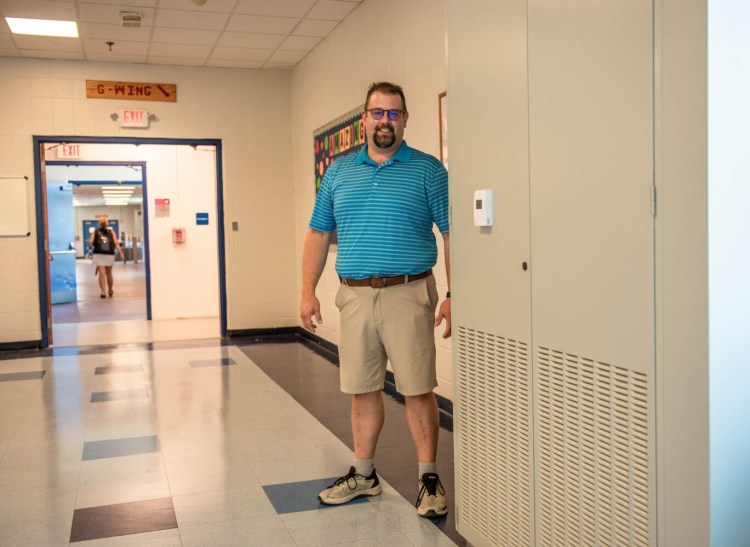 Jay Dufour, assistant principal at Lewiston High School, stands on Thursday next to one of the new air exchange units the district purchased with federal COVID relief funds. There are 12 units in the cafeteria, gym and multi purpose room which heat and cool the air..