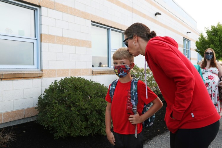 PORTLAND, ME - AUGUST 31: Tamothy (cq) Louten kisses her second-grade son Landon Louten as he waits to enter East End Community School for the first day of class. (Staff photo by Ben McCanna/Staff Photographer)