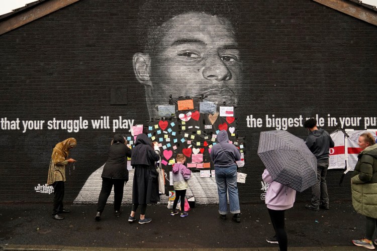 People place messages of support on top of bin liners that were taped over offensive wording on the mural of Manchester United striker and England player Marcus Rashford on the wall of the Coffee House Cafe on Copson Street, which appeared vandalised the morning after the England soccer team lost the Euro 2021 final against Italy, in Withington, Manchester, England, Monday,  July 12, 2021.  