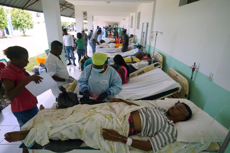 People injured in the earthquake are attended outside the Ofatma Hospital because some interior walls were cracked by the earthquake in Les Cayes, Haiti, on Wednesday. (AP Photo/