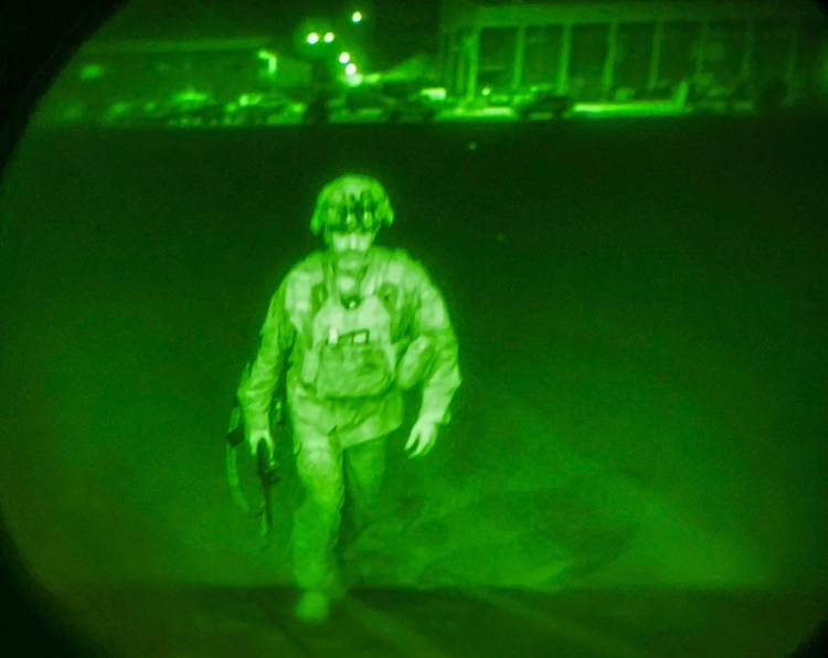 In this image made through a night vision scope and provided by U.S. Central Command, Maj. Gen. Chris Donahue, commander of the U.S. Army 82nd Airborne Division, XVIII Airborne Corps, boards a C-17 cargo plane at the Hamid Karzai International Airport in Kabul, Afghanistan, Monday, Aug. 30, 2021, as the final American service member to depart Afghanistan. (U.S. Central Command via AP)