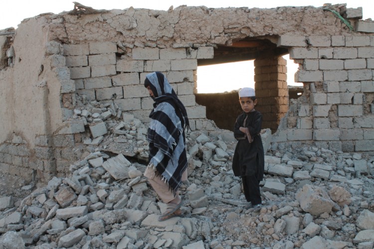 Afghan boys walk near a damaged house Saturday after airstrikes two weeks ago during a fight between government forces and the Taliban in Lashkar Gah, Helmand province, southwestern, Afghanistan.