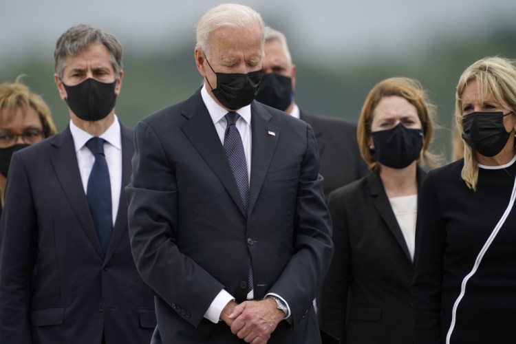 President Biden bows his head as first lady Jill Biden, right, and Secretary of State Antony Blinken, left, watch during a casualty return at Dover Air Force Base, Del., on Sunday for the 13 service members killed in the suicide bombing in Kabul, Afghanistan, on Thursday. 

