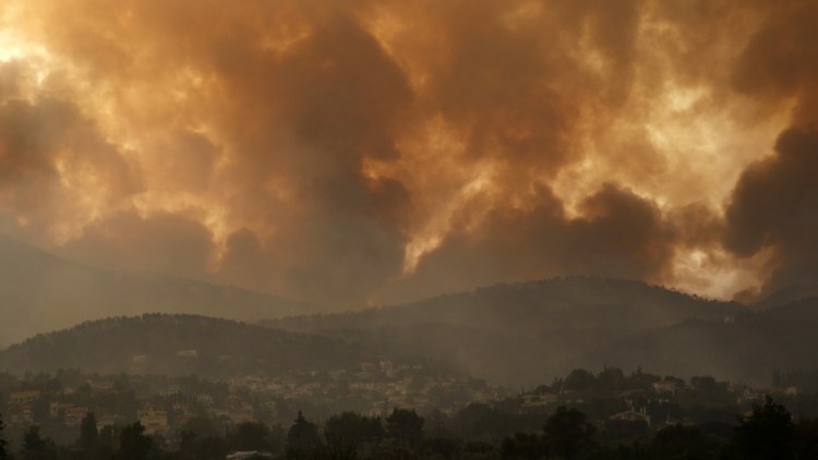 Smoke spreads over Mount Parnitha during a wildfire in Ippokratios Politia village, about 21 miles  north of Athens, Greece, on Friday.

