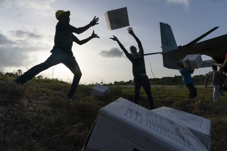 Haitian aid workers unload food from a VM-22 Osprey at Jeremie Airport on  Saturday in Jeremie, Haiti.

