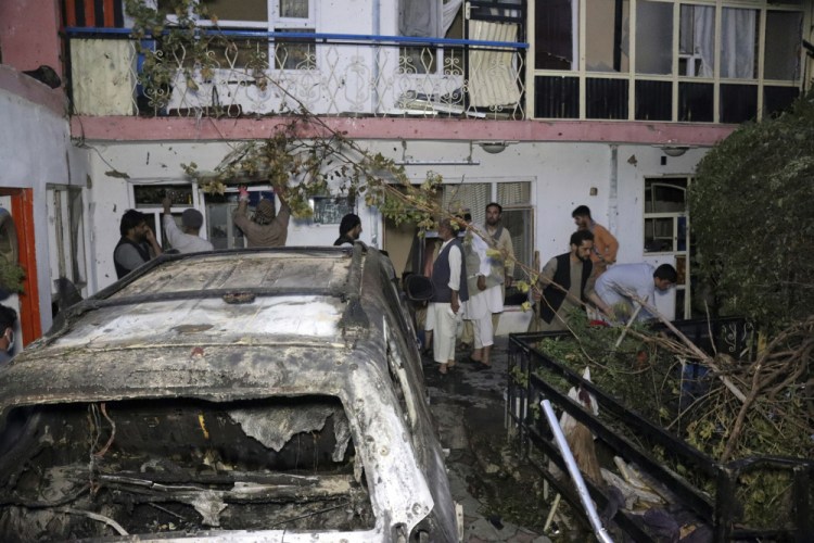 Afghan people are seen inside a house after U.S. drone strike in Kabul, Afghanistan, Sunday. A U.S. drone strike destroyed a vehicle carrying "multiple suicide bombers" from Afghanistan's Islamic State affiliate on Sunday before they could attack the ongoing military evacuation at Kabul's international airport, American officials said. 