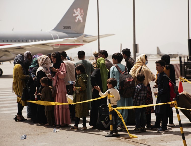 Civilians prepare to board a plane during an evacuation Wednesday at Hamid Karzai International Airport, Kabul, Afghanistan.