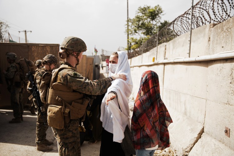 Two civilians are processed through a checkpoint during an evacuation at Hamid Karzai International Airport, in Kabul, Afghanistan, on Wednesday. 