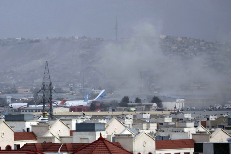 Smoke rises from a deadly explosion outside the airport in Kabul, Afghanistan, on Thursday. Two suicide bombers and gunmen targeted crowds massing near the airport in the waning days of a massive airlift that has drawn thousands of people seeking to flee the Taliban takeover of Afghanistan. 