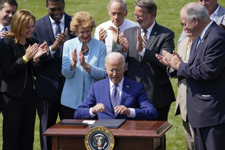 President Biden signs an executive order on increasing production of electric vehicles after speaking Thursday on the South Lawn of the White House in Washington, during an event on clean cars and trucks.