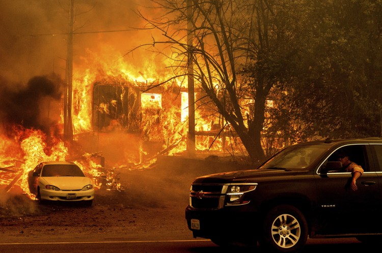 Flames from the Dixie Fire consume a house in Plumas County, Calif.  on Thursday.