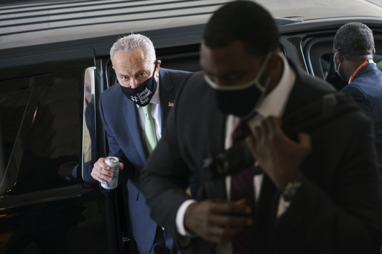 Senate Majority Leader Chuck Schumer, D-N.Y., arrives with his security detail as senators convene for a rare weekend session to continue work on the $1 trillion bipartisan infrastructure bill Sunday at the Capitol in Washington.
