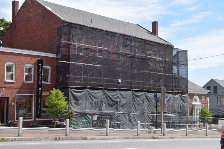 The front of the Wawenock Block building in downtown Wiscasset is covered in scaffolding to stabilize it and prevent more bricks from falling off. The building owner still doesn't know when repairs on the building will begin. 
