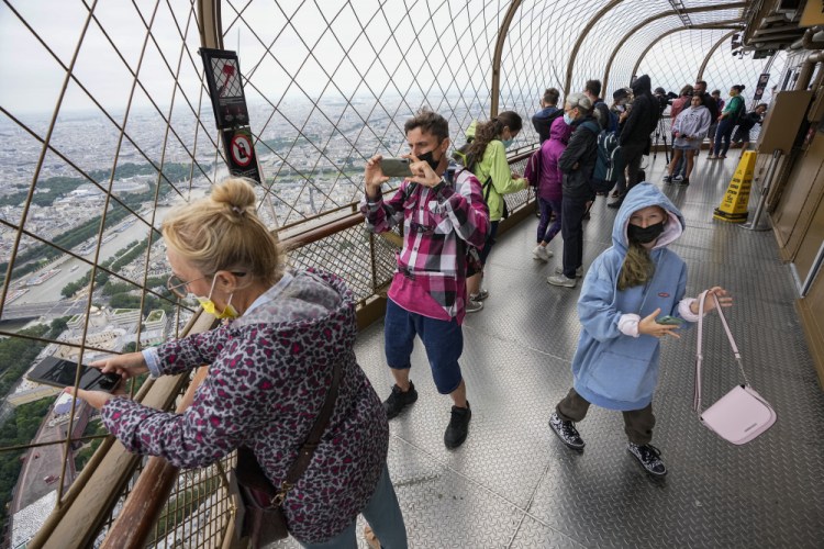 Visitors enjoy the view from top of the Eiffel Tower in Paris on July 16. 