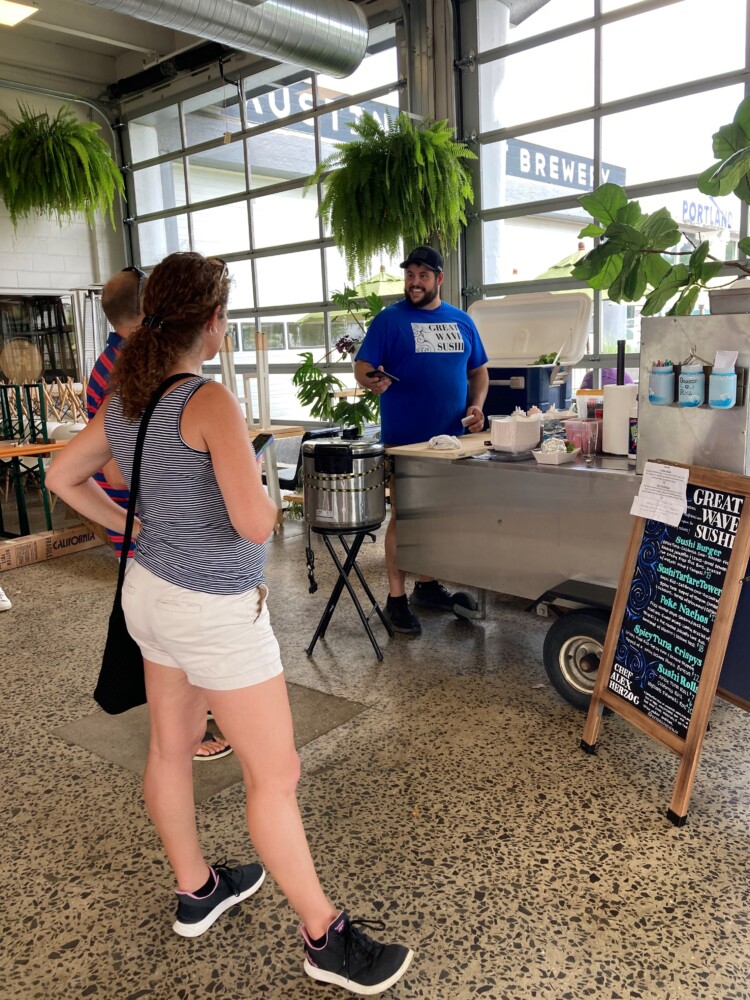 Alex Herzog, chef and founder of the Great Wave Sushi cart, chats with a customer inside the Austin Street Brewery in Portland on a July afternoon. 
